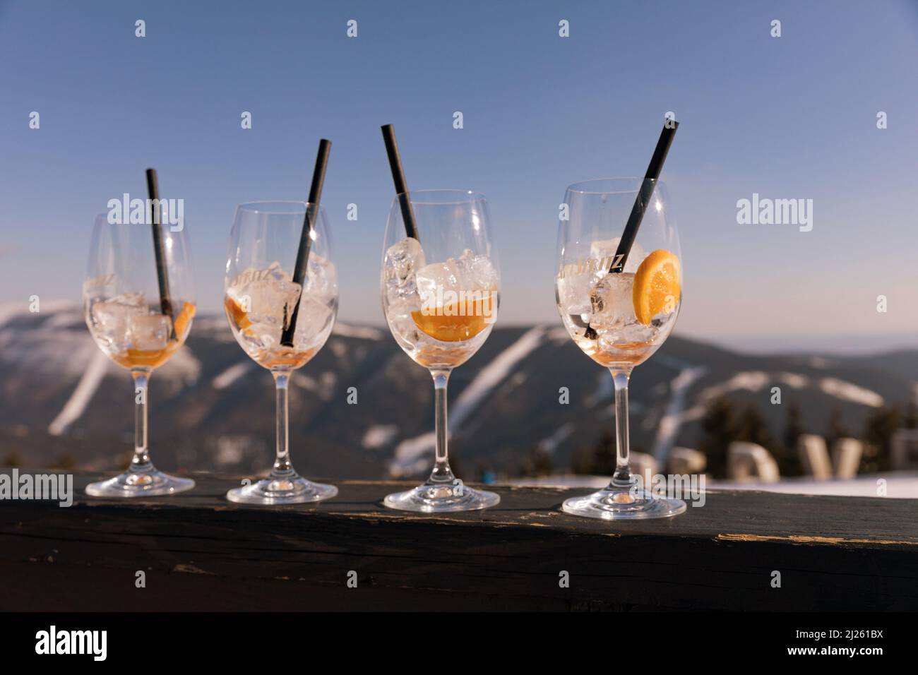 Medvedin, wooden letters at the top of the ski resort. Glass on Aperol Spritz in the foreground of the inscription Medvedi. Suitable for advertising w Stock Photo