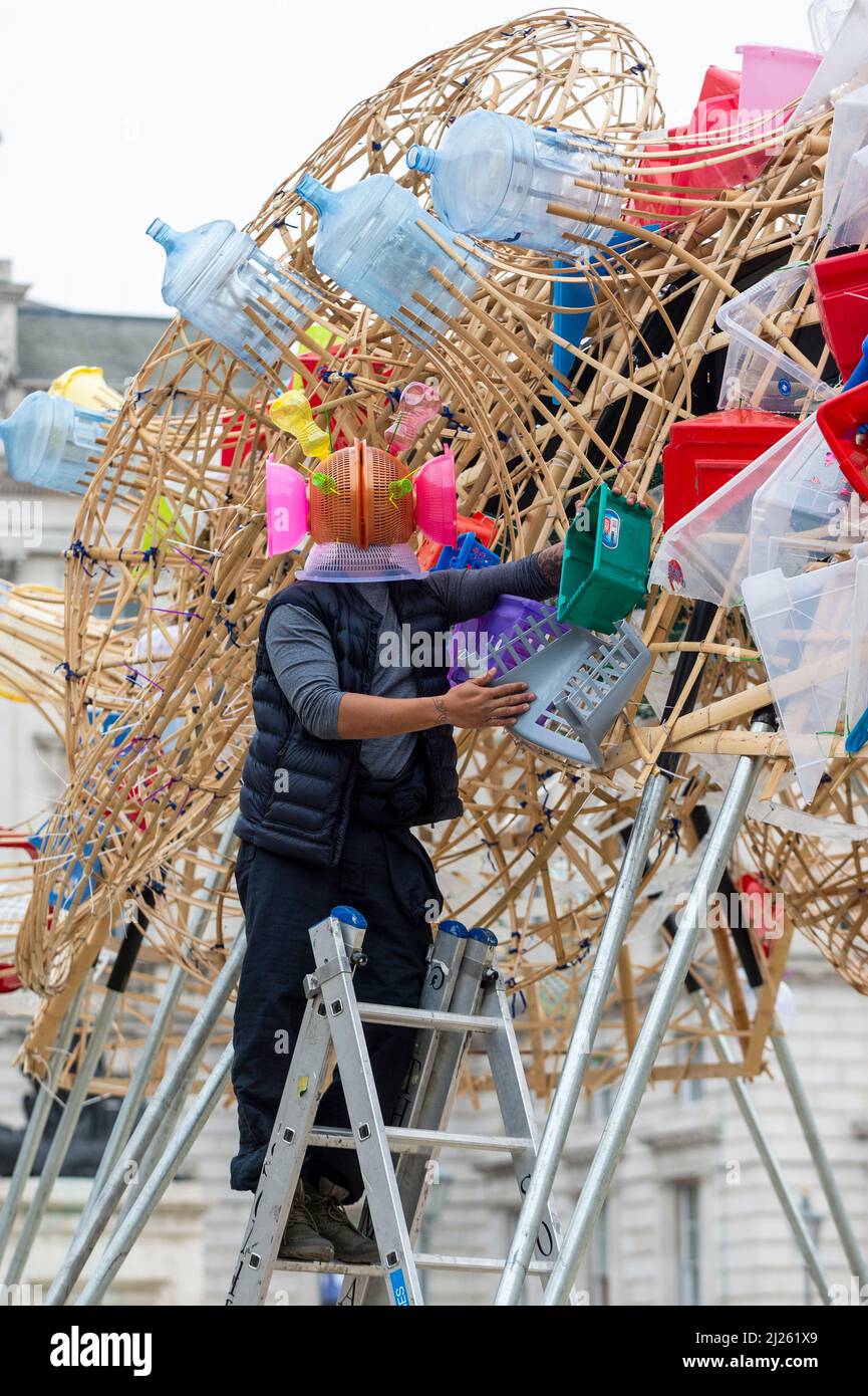 London, UK.  30 March 2022. Philippine artist Leeroy New poses at ‘The Arks of Gimokudan’, his installation unveiled at Somerset House to mark the occasion of Earth Day. This is New’s first UK installation and comprises three fantastical upturned ships constructed using plastic waste and recycled materials.  The installation, on show to 26 April, draws on the culture and mythologies of the Philippines, a country at the frontline of the climate emergency  Credit: Stephen Chung / Alamy Live News Stock Photo