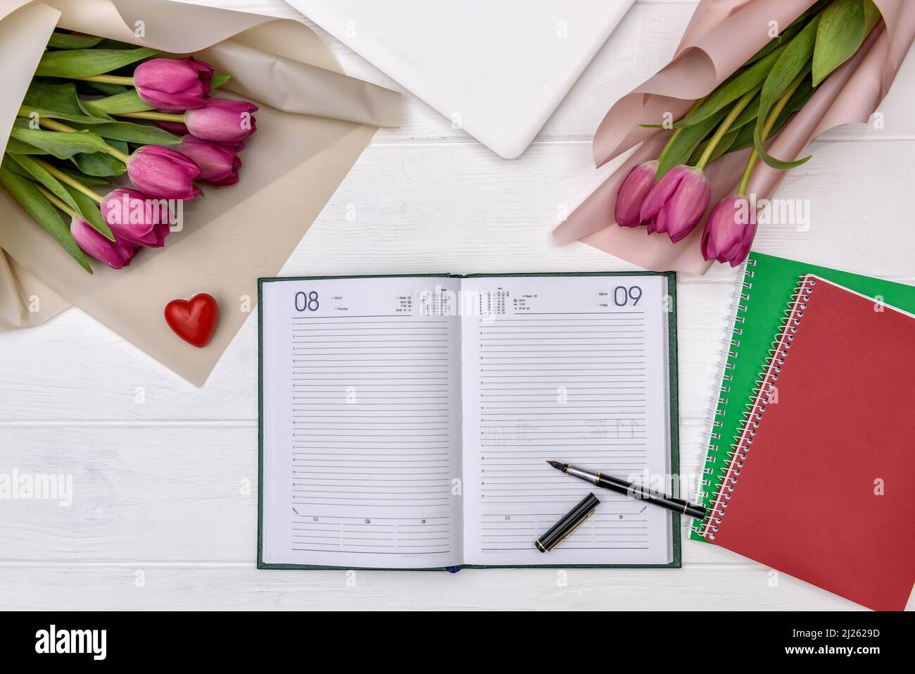Blank notepad with tulips on wooden table Stock Photo