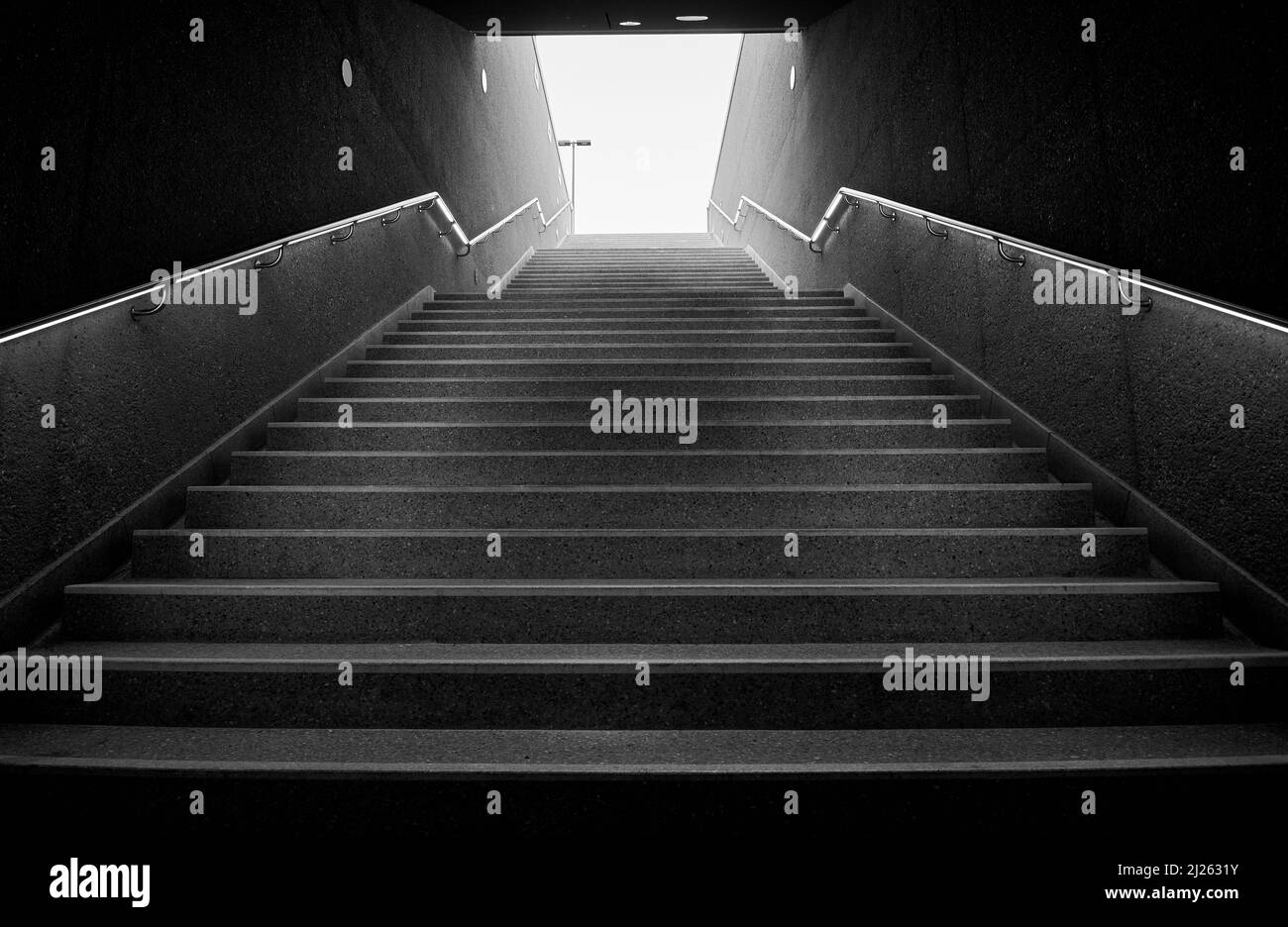 Dark underground stairs leading up into the light Stock Photo