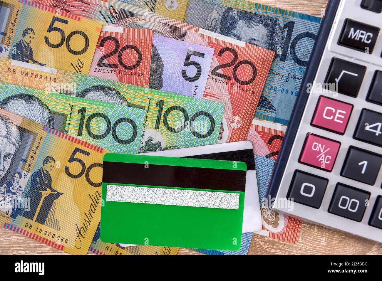 Cash and credit card. Colorful australian dollar banknotes with plastic banking card and calculator on table. Financial system Stock Photo