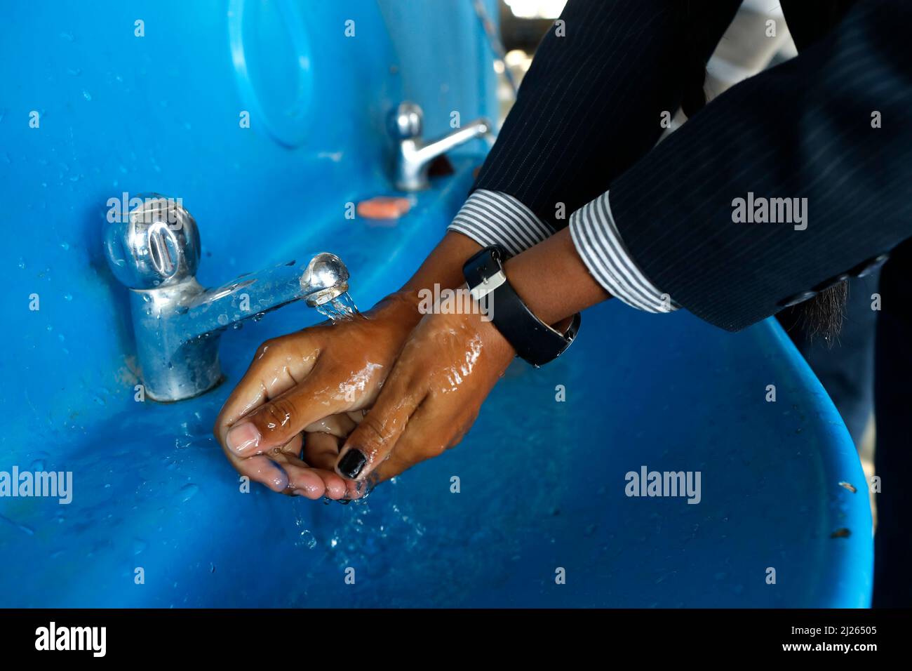 Secondary school. Boy school wash his hands with soap in the sink. Stock Photo