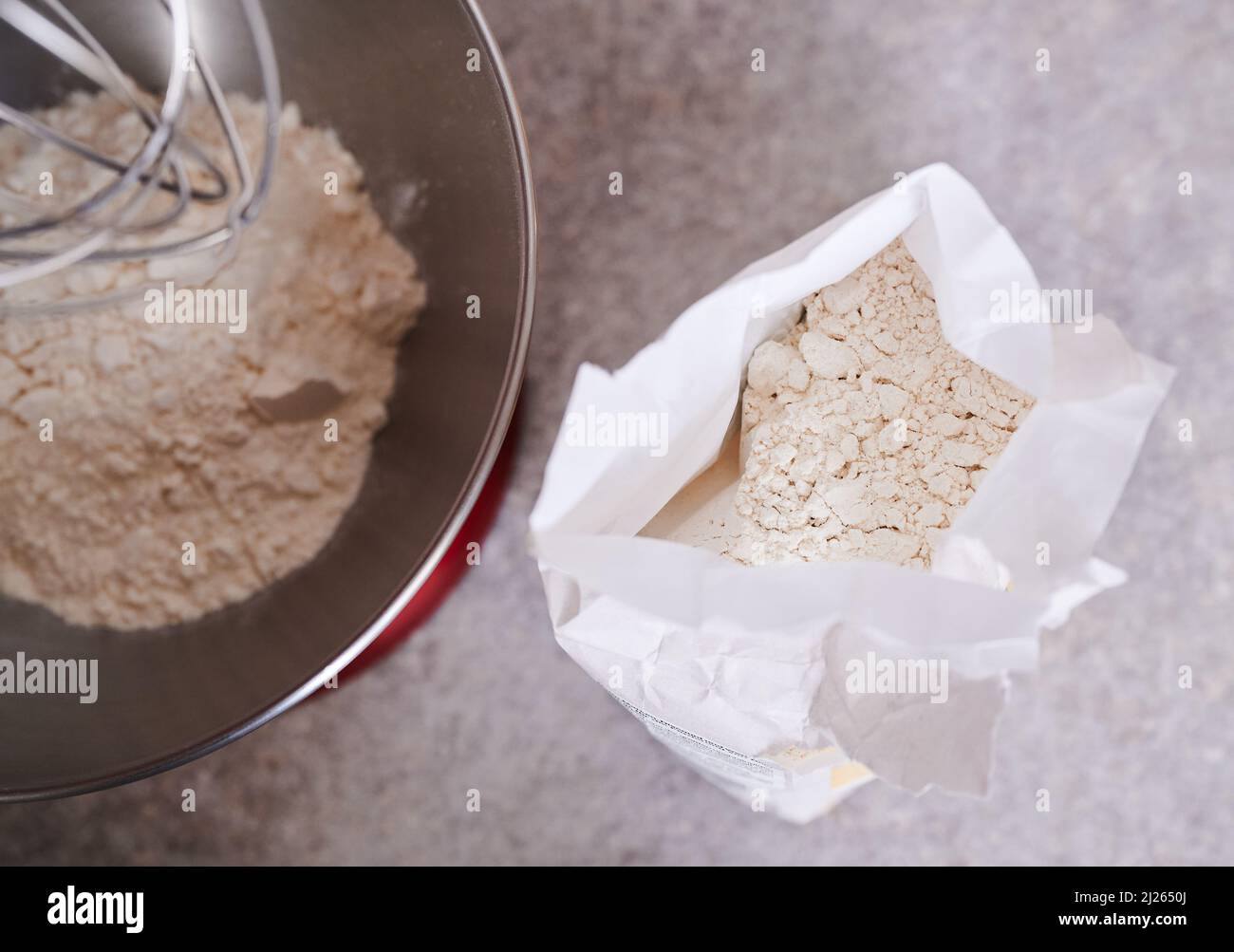 Berlin, Germany. 30th Mar, 2022. ILLUSTRATION - Flour lies in a mixing bowl while a packet of flour stands next to it. According to economists, consumers in Germany will have to prepare for further price increases. Those who buy food will have to dig deeper into their pockets. Credit: Annette Riedl/dpa/Alamy Live News Stock Photo