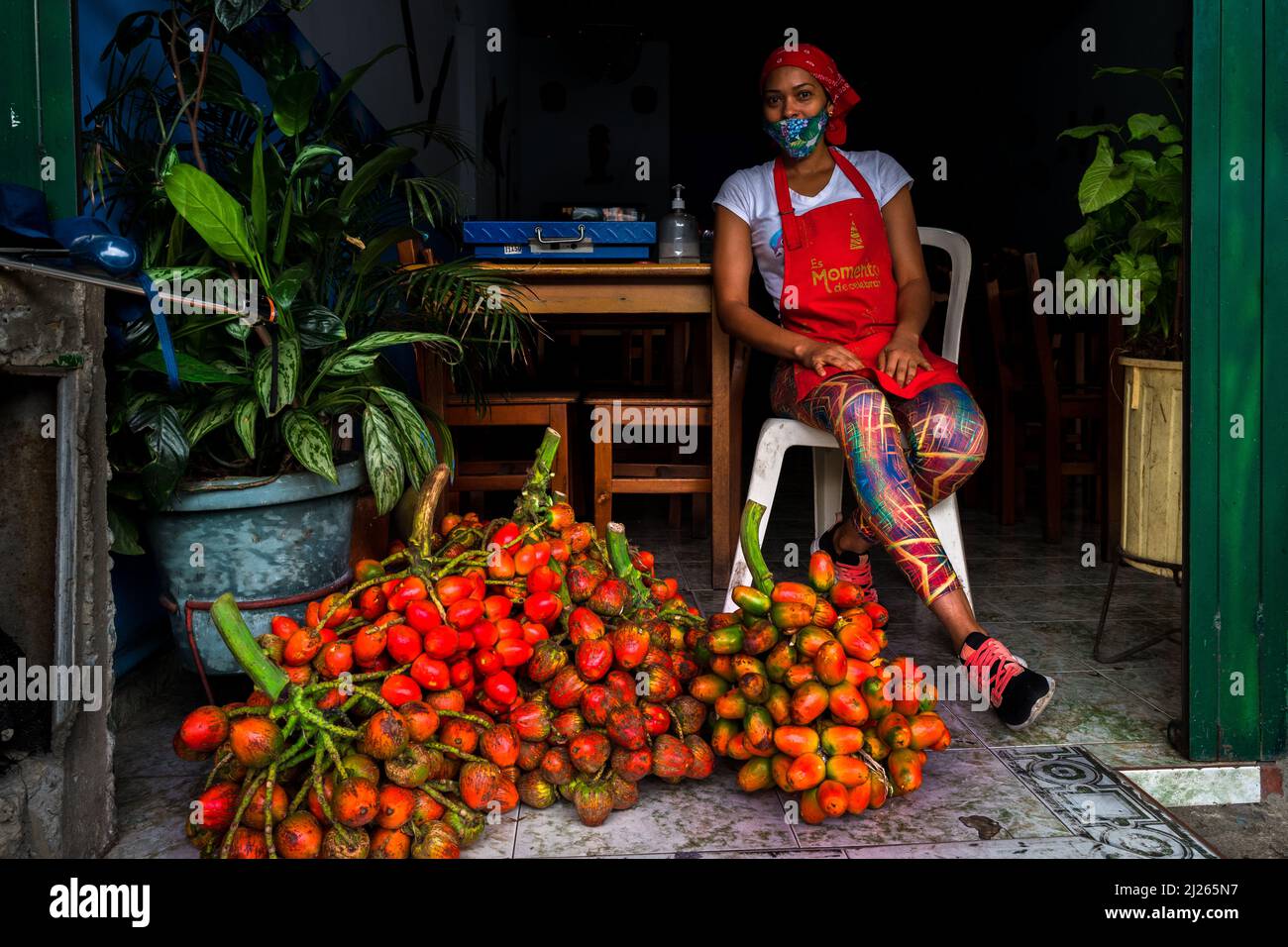 An Afro-Colombian woman sells raw chontaduro (peach palm) fruits in a street restaurant in Cali, Valle del Cauca, Colombia. Stock Photo