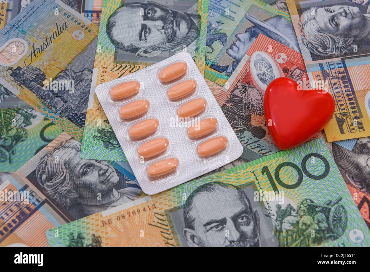 Healthcare cost. Australian dollars with red heart and pills in blister Stock Photo