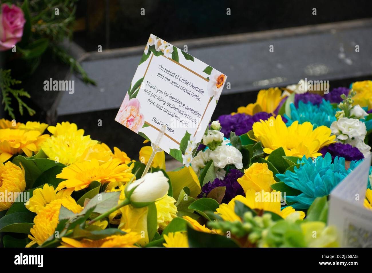 Melbourne, Australia. 30th March 2022. Flowers laid by Cricket Australia sits underneath the Shane Warne statue at the memorial service commemorating his life. Credit: Jay Kogler/Alamy Live News Stock Photo