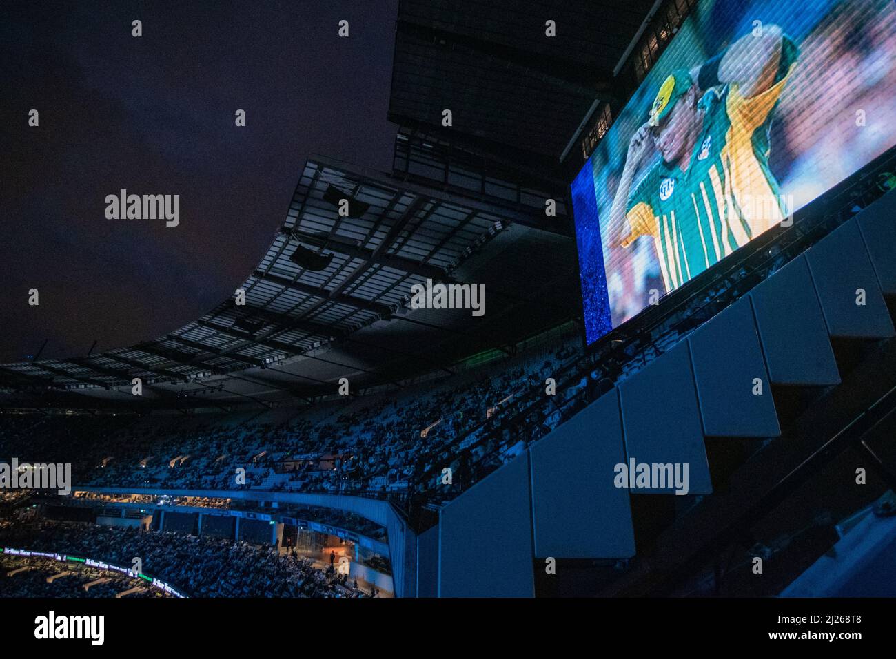 Melbourne, Australia. 30th March 2022. The crowd at the Shane Warne memorial service as a clip of the bowler plays on the screen. Credit: Jay Kogler/Alamy Live News Stock Photo