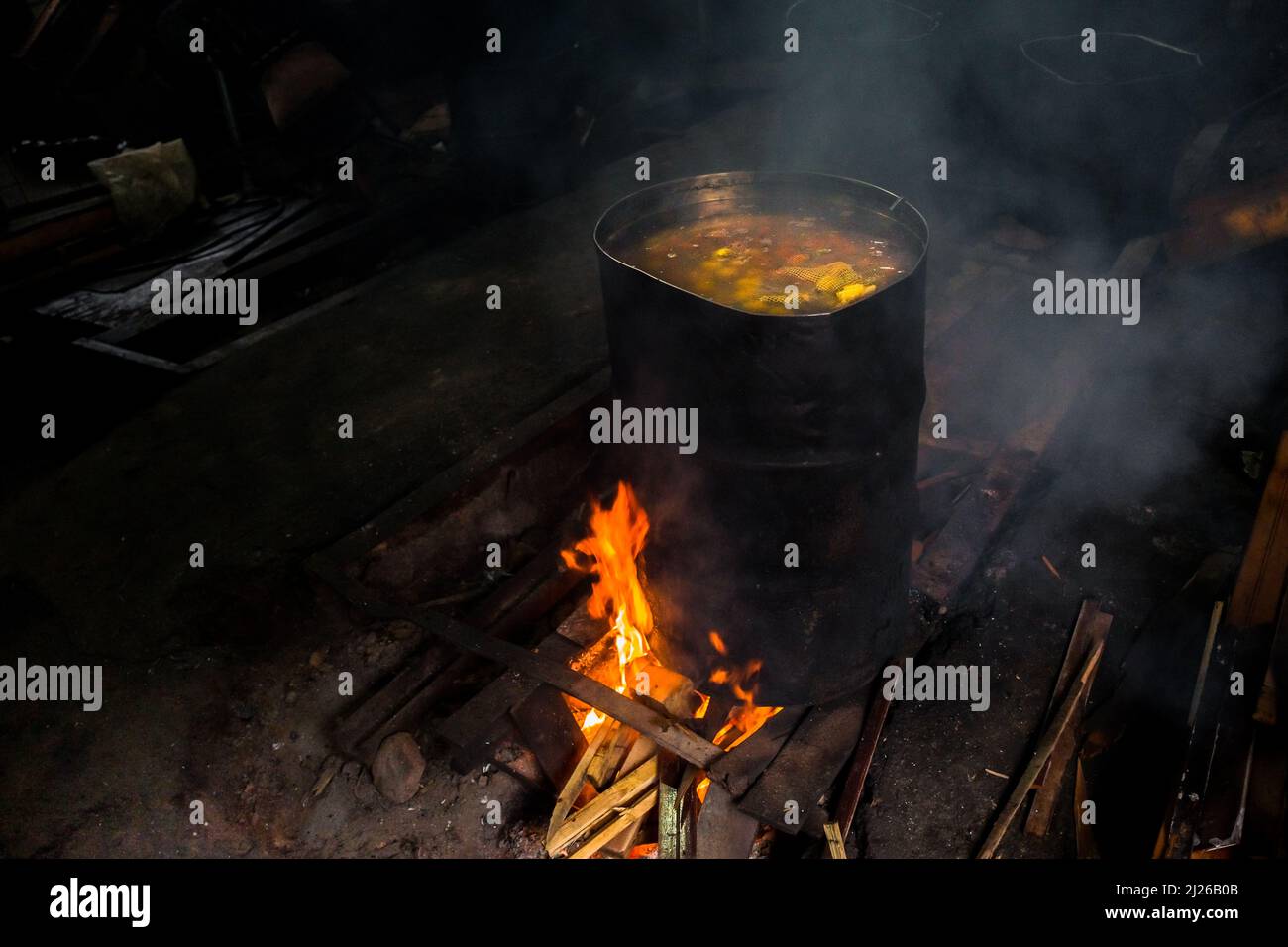 Raw chontaduro (peach palm) fruits are seen being cooked in a barrel in a processing facility in Cali, Valle del Cauca, Colombia. Stock Photo
