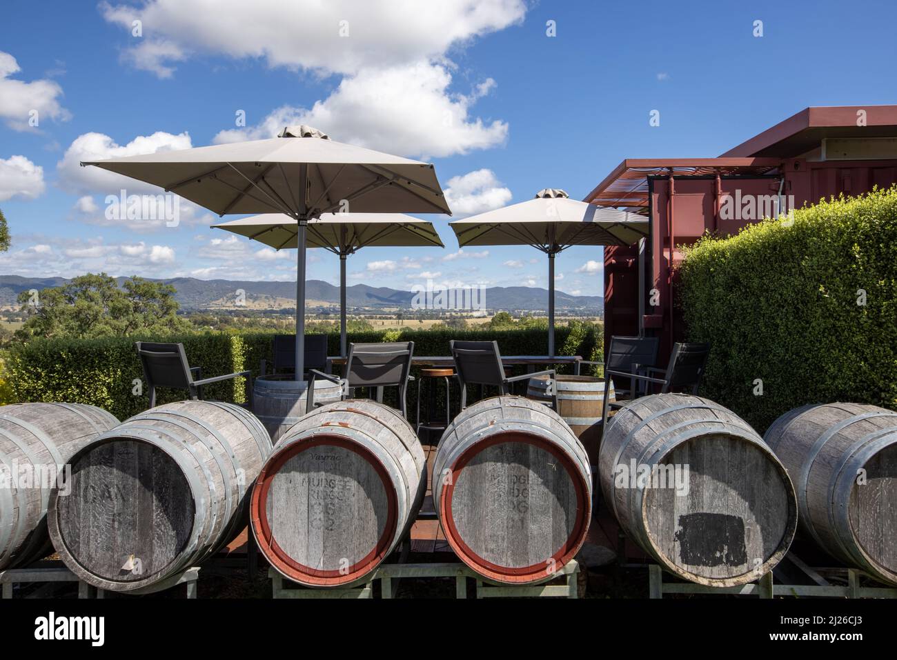 The wine barrels and empty tables with umbrellas at the outdoor
