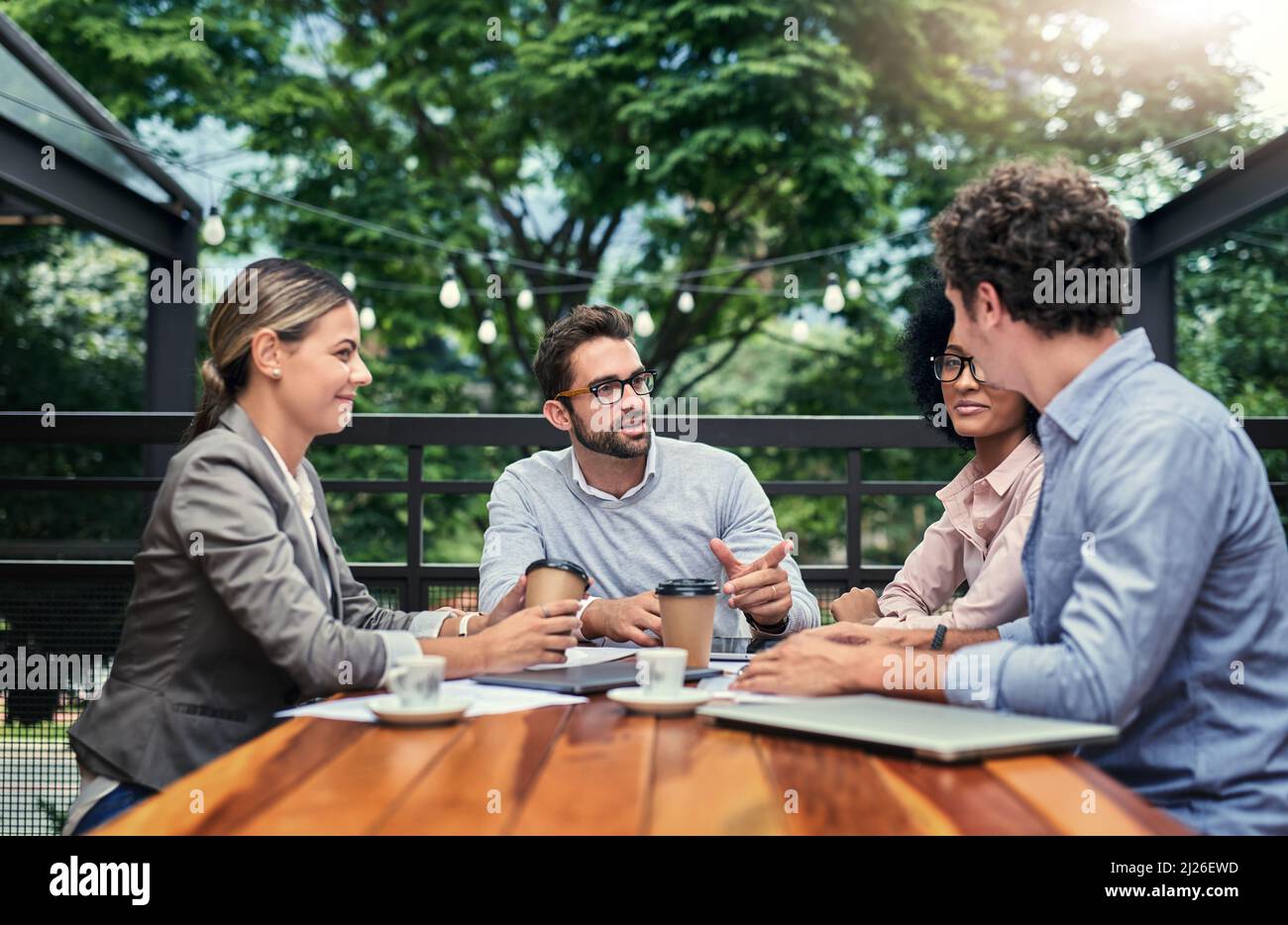 Location, location, location. Cropped shot of a group of business colleagues having a meeting outdoors at a cafe. Stock Photo