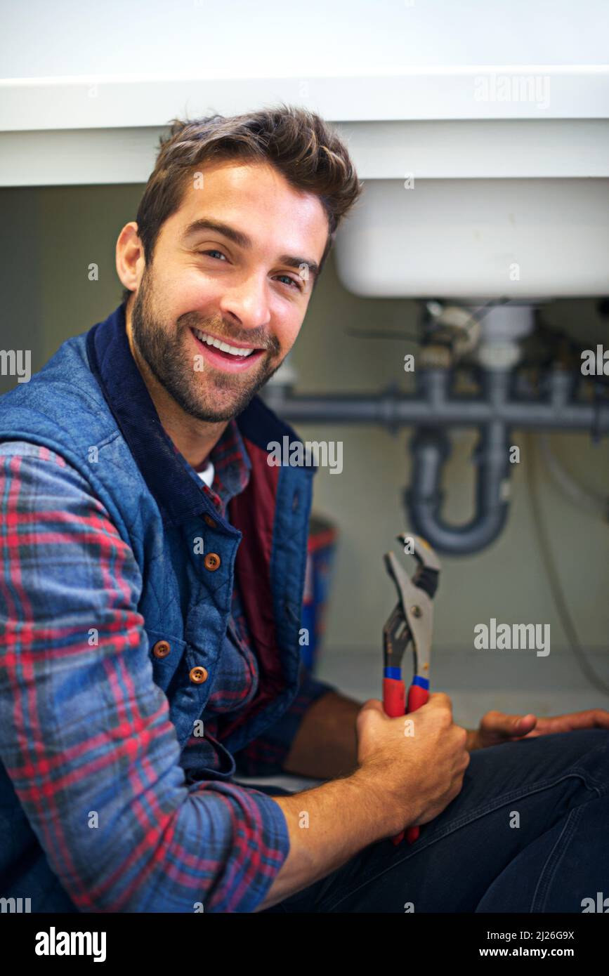 The right tool for the job. Shot of a plumber fixing a pipe Stock Photo
