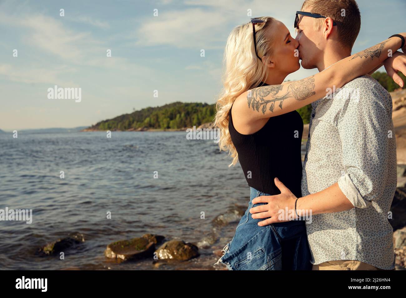 Young Blond Woman Smooching Boyfriend At Beach Stock Photo - Alamy