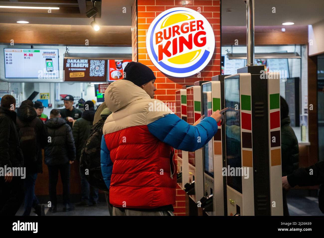 Moscow Russia. 30th of March 2022 A man in a jacket of the colors of the Russian flag makes an order in the Burger King restaurant at the Belorussky Railway Station on