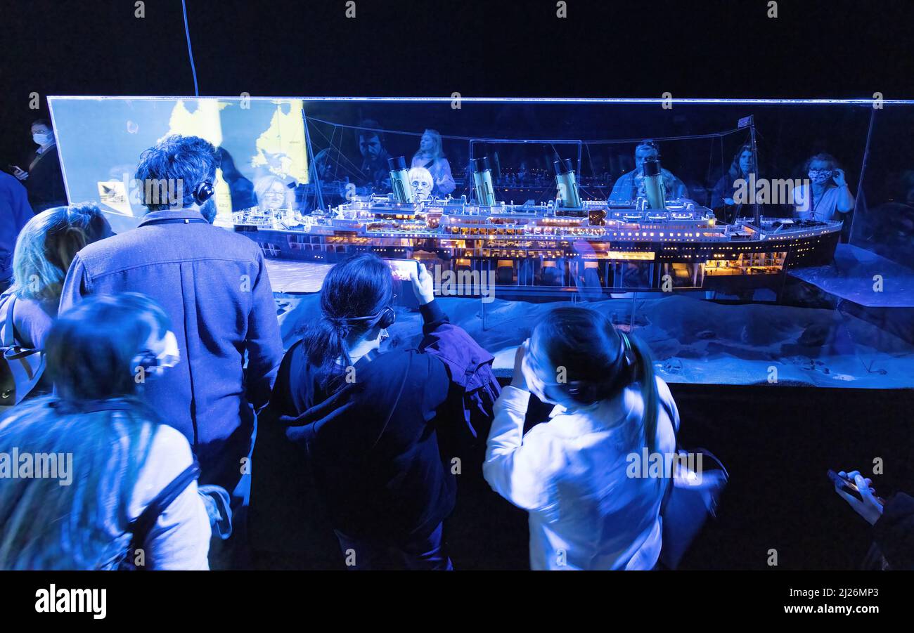 The Titanic sinking - visitors looking at a Titanic ship model, The Titanic Exhibition, London UK Stock Photo