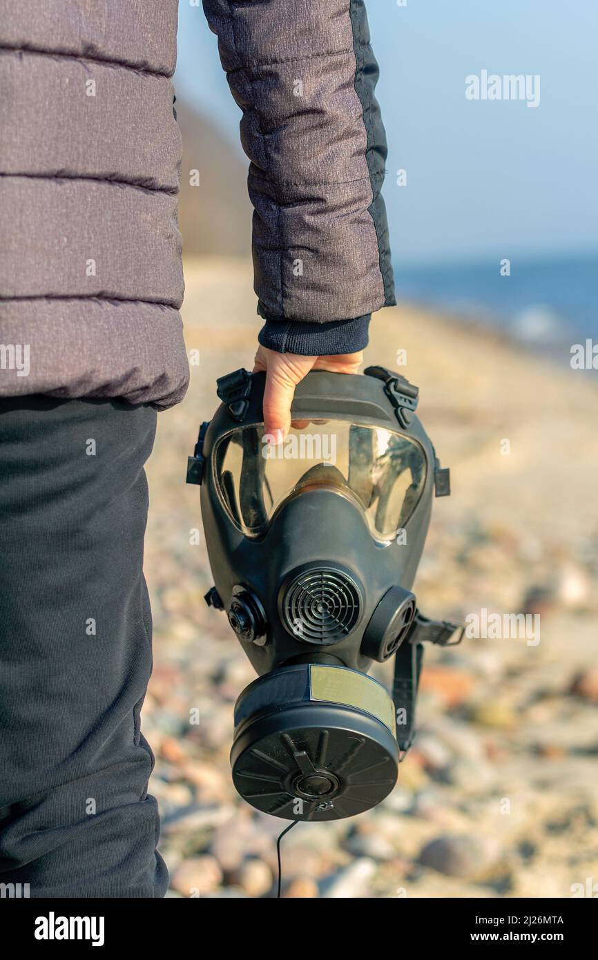 A boy holding a gas mask in his hand Stock Photo - Alamy