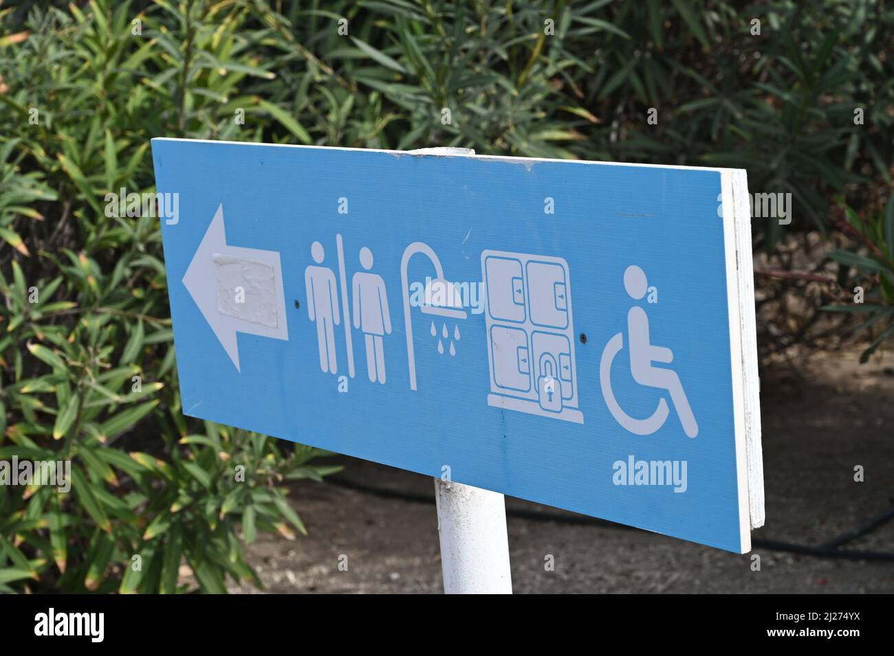 A blue directional sign pointing to the restrooms , showers, Wc, loo, toilet, for men women and having disabled access Stock Photo