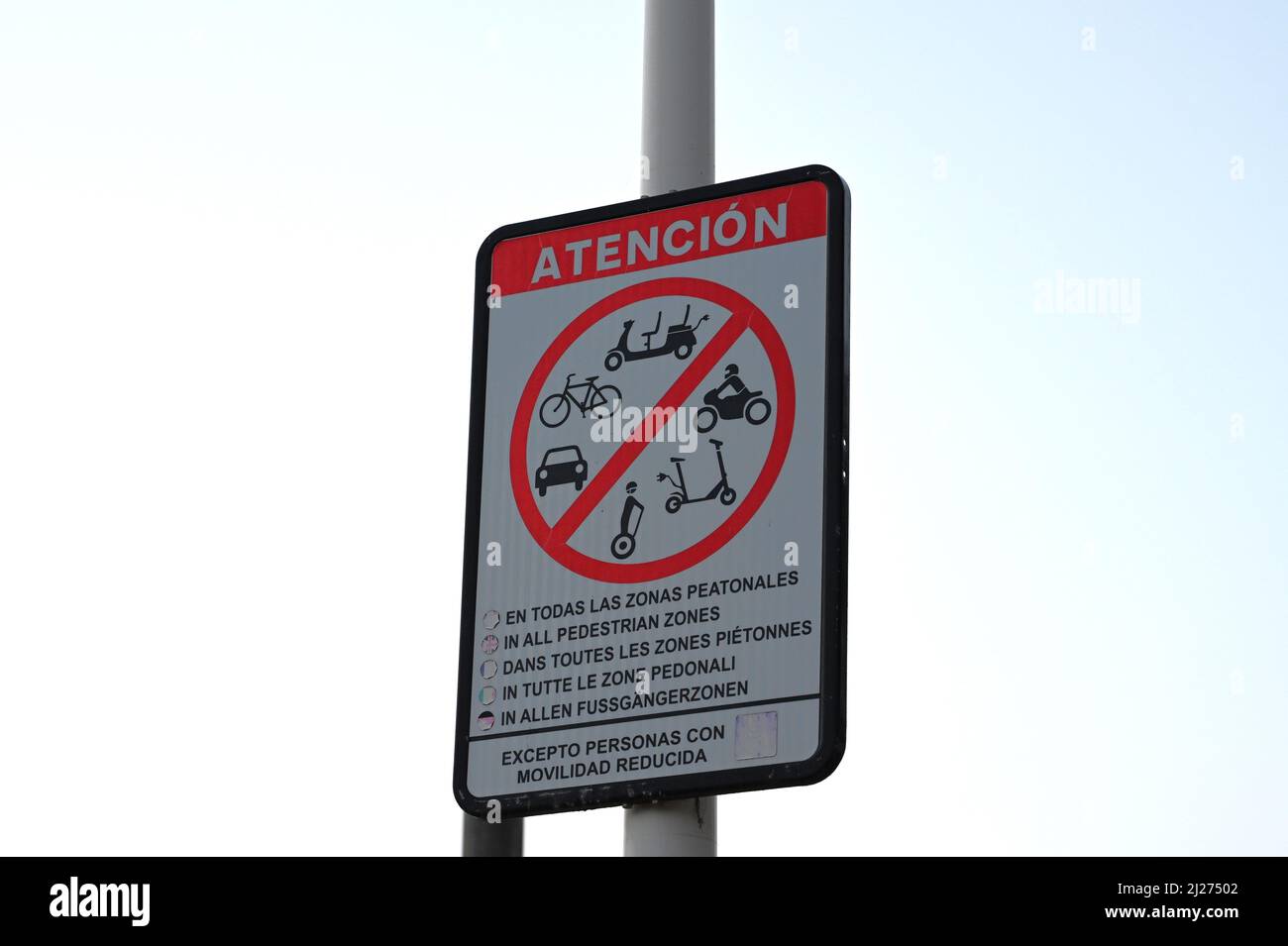 A Spanish attention, atencion sign restricting the use of mobility scooters, bicycles, segways, motorbikes, scooters, cars Stock Photo