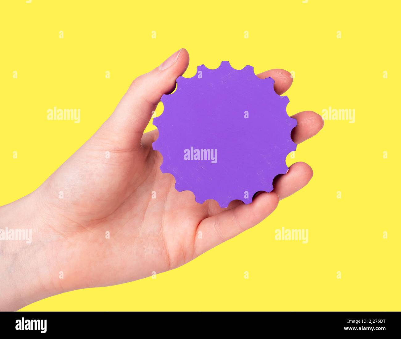 Settings concept. Woman hand with violet gear on yellow background. Applications technical maintenance. Cog wheel. High quality photo Stock Photo