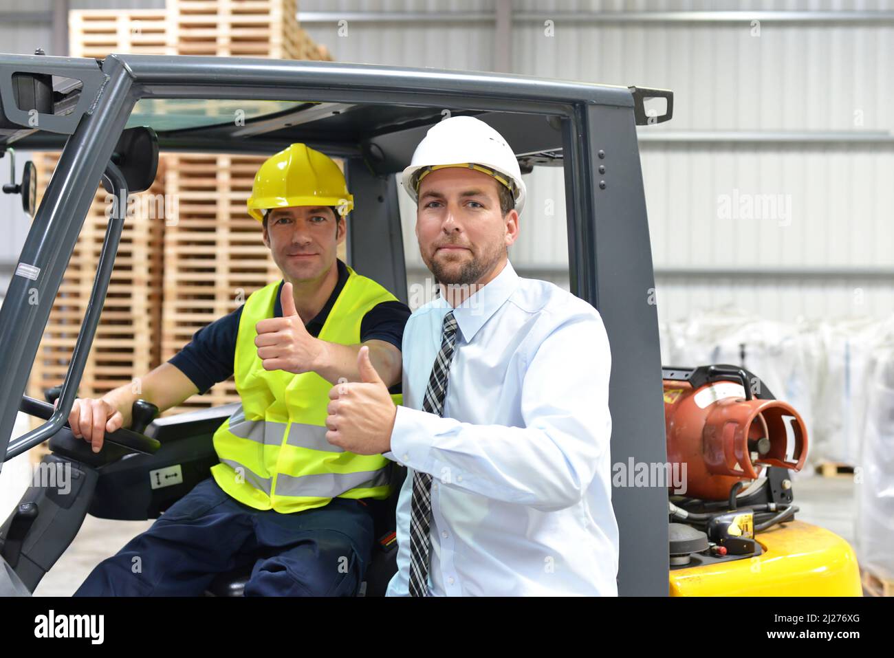 meeting of the manager and worker in the warehouse - forklift and interior of the industrial building Stock Photo