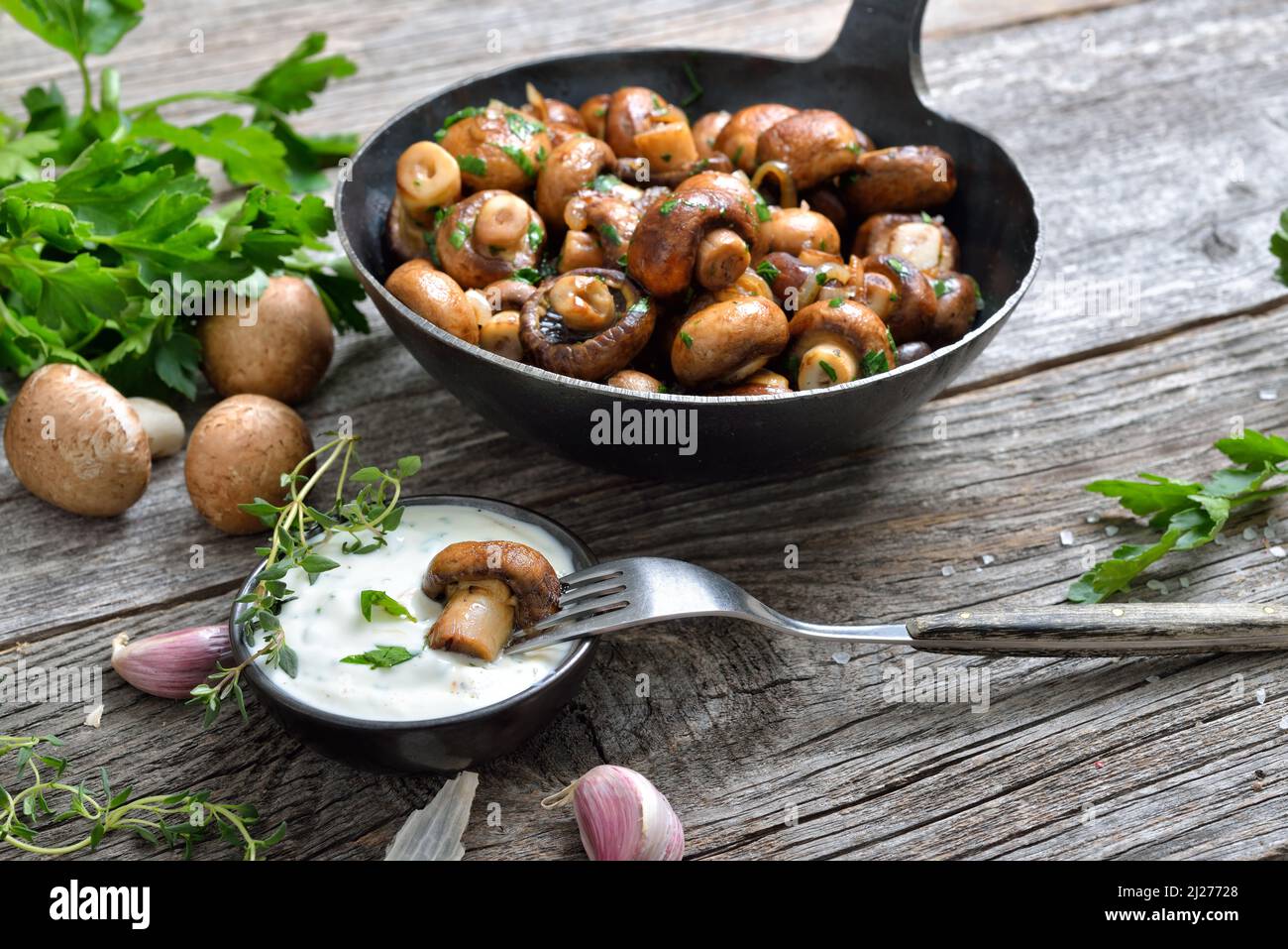 Fried mushrooms with shallots and parsley, served with a sour cream dip with herbs and garlic Stock Photo