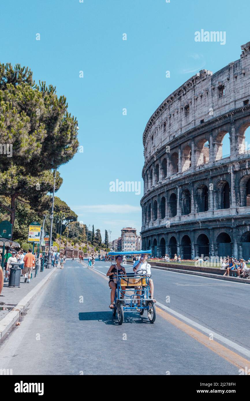 Side view of the Ancient Roman Colosseum, Rome, Italy. Colosseum and tourists in summer day for poster, calendar, post, screensaver, wallpaper, card Stock Photo