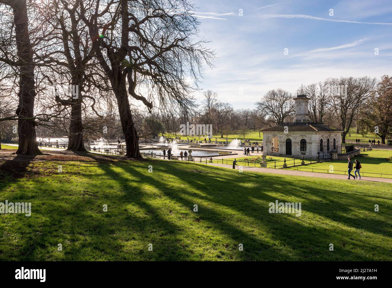 Trees cast long shadows at the Italian Gardens in Hyde Park, London on a bright and sunny winter's day. Stock Photo