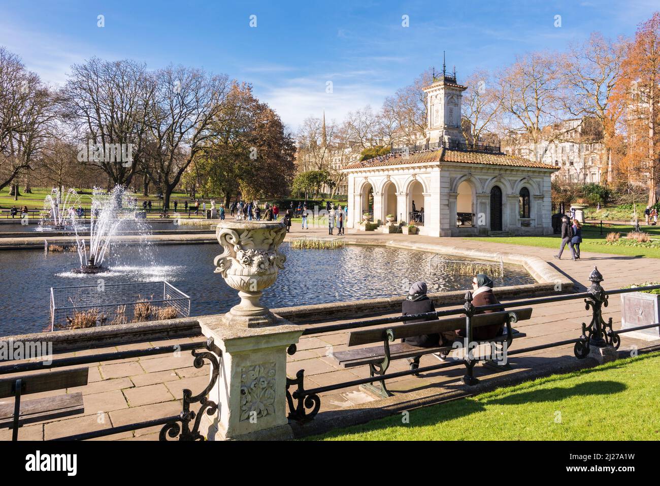 Visitors at the Italian Gardens in Hyde Park, London on a bright and sunny winter's day. Stock Photo