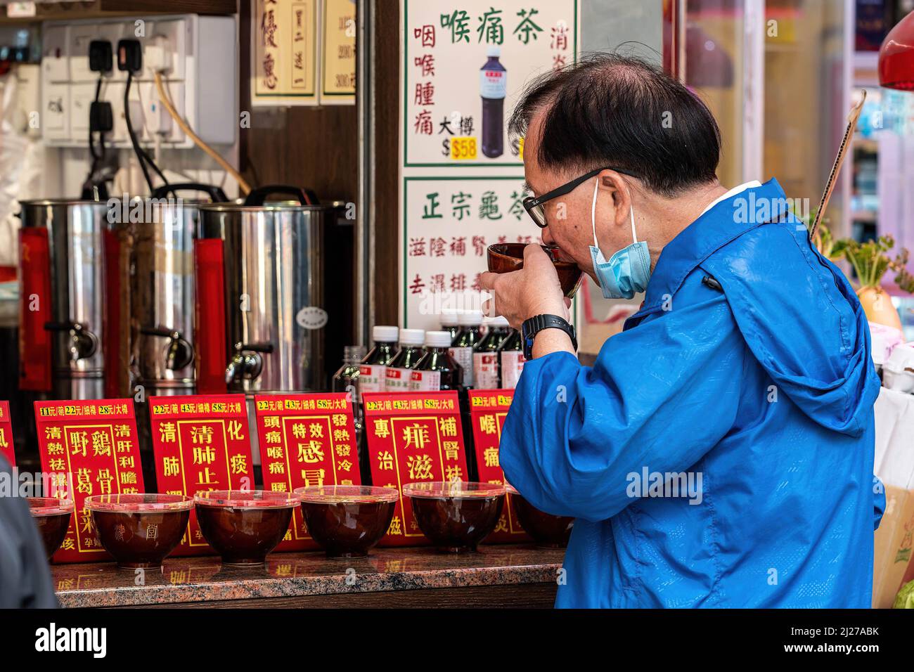 A man consumes medicinal herbal tea at a shop in North Point. The Hong Kong government has been actively promoting the use of traditional Chinese medicine for the treatment of COVID-19. However, experts are concerned that there isn't enough evidence from controlled peer-reviewed trials on the effectiveness of these treatments for the novel coronavirus. Stock Photo