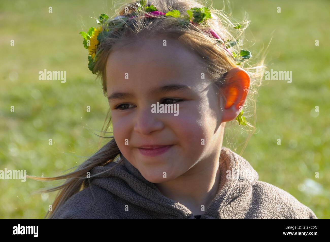 young smiling girl in a meadow wearing a hand made chaplet in her hair ,spring summer holiday Stock Photo
