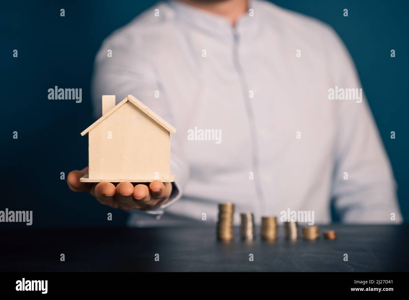 Real estate agent hand holdinga house model. Realtor, mortgage, your house, home loan concept. Copy space Stock Photo