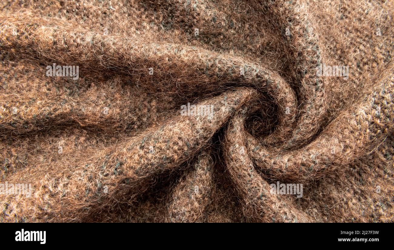 Twisted brown lambswool fabric with waves and curves. Wool material