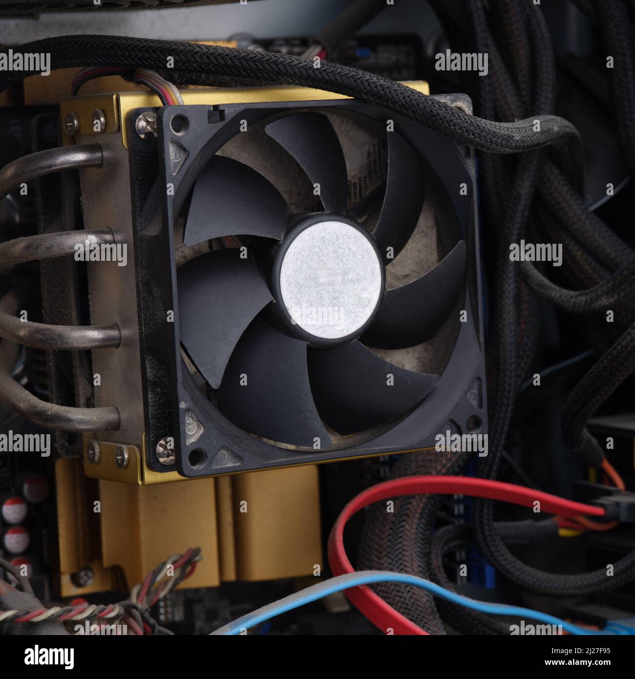 A dusty CPU fan in a computer case. Close up. Stock Photo