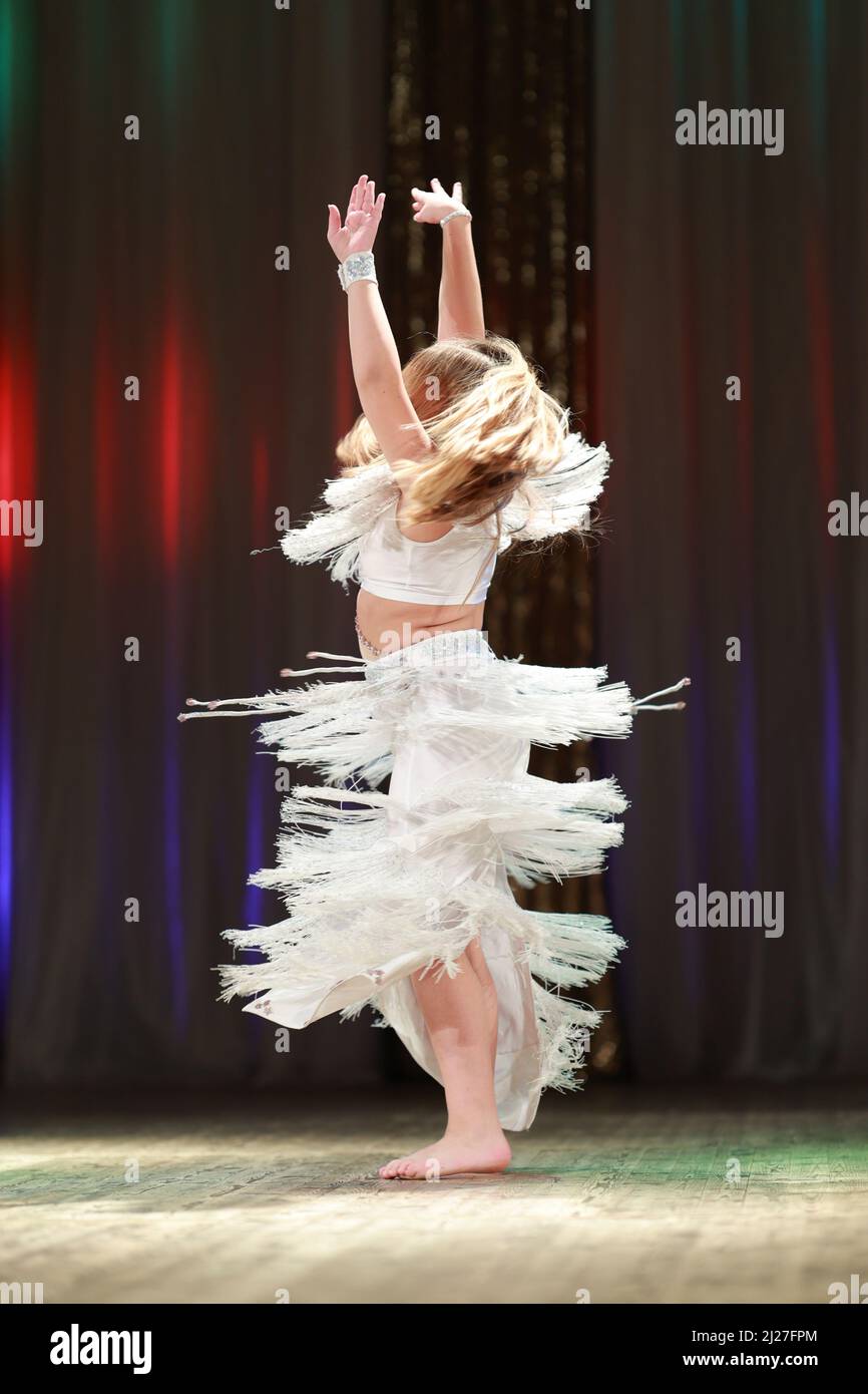 Girls dancers perform on stage with multicolored lights. Backstage