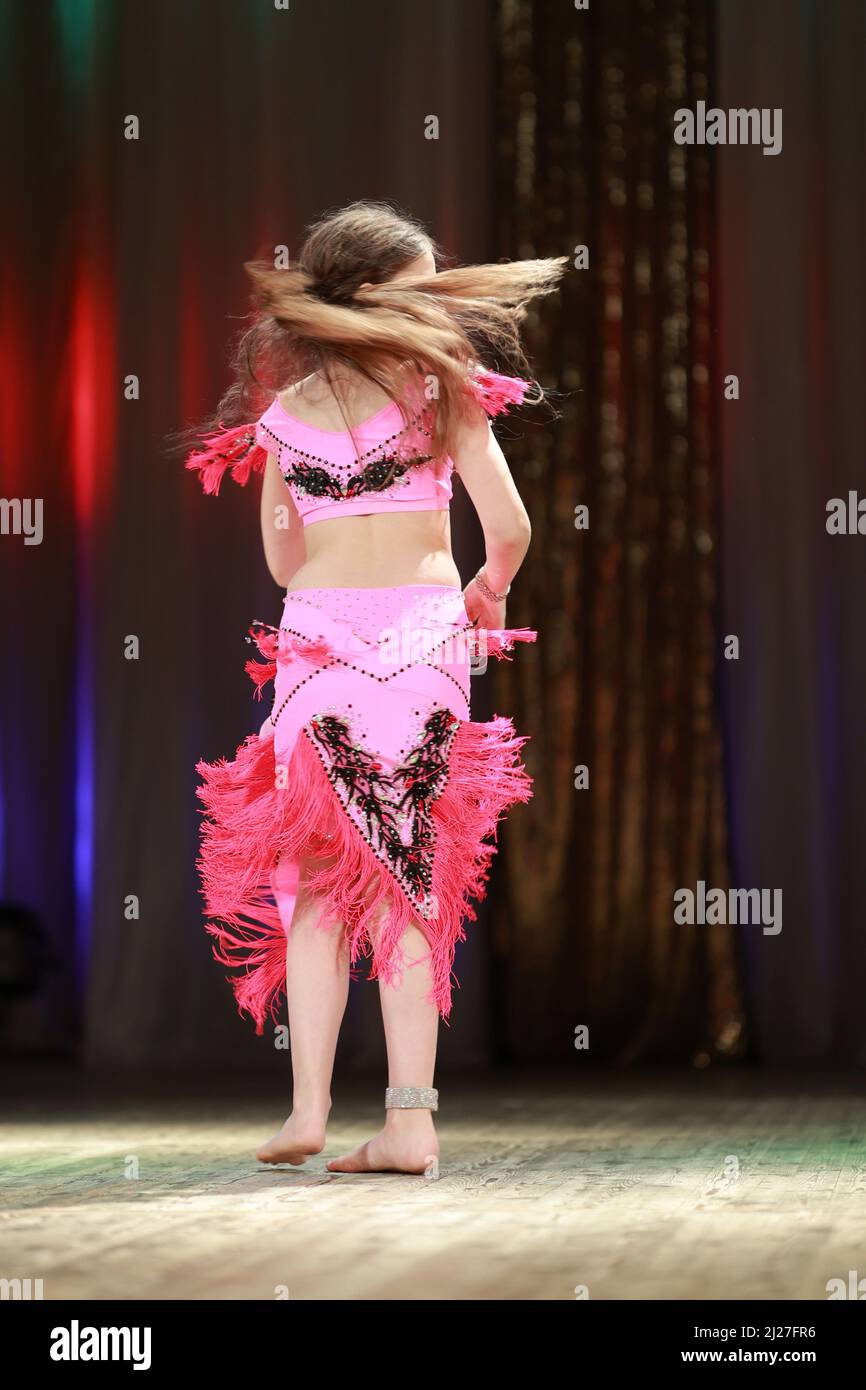 Girls dancers perform on stage with multicolored lights. Backstage