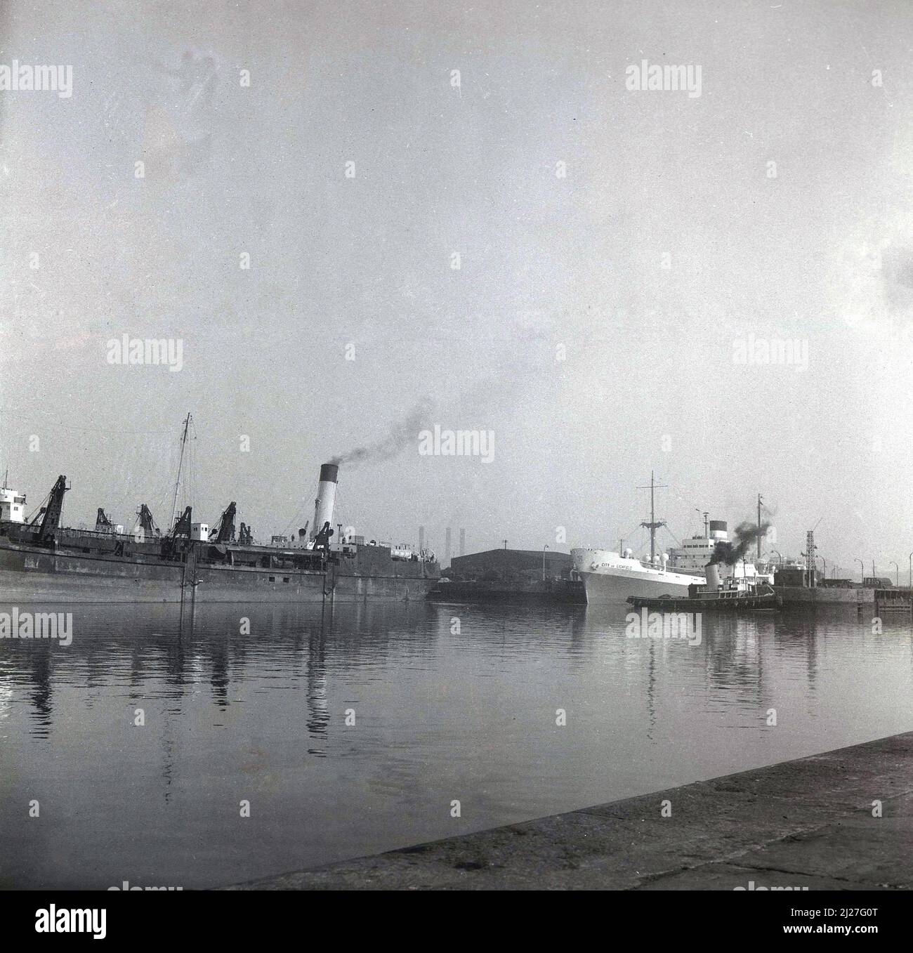 1961, historical, cargo ships moored at Birkenhead docks, Mersey, Liverpool, England including a steam barge and ship, City of Lichfield, a motor vessel built by William Denny & Bros on the Clyde for shipping company Ellerman Lines. She was launched in November 1960. Stock Photo