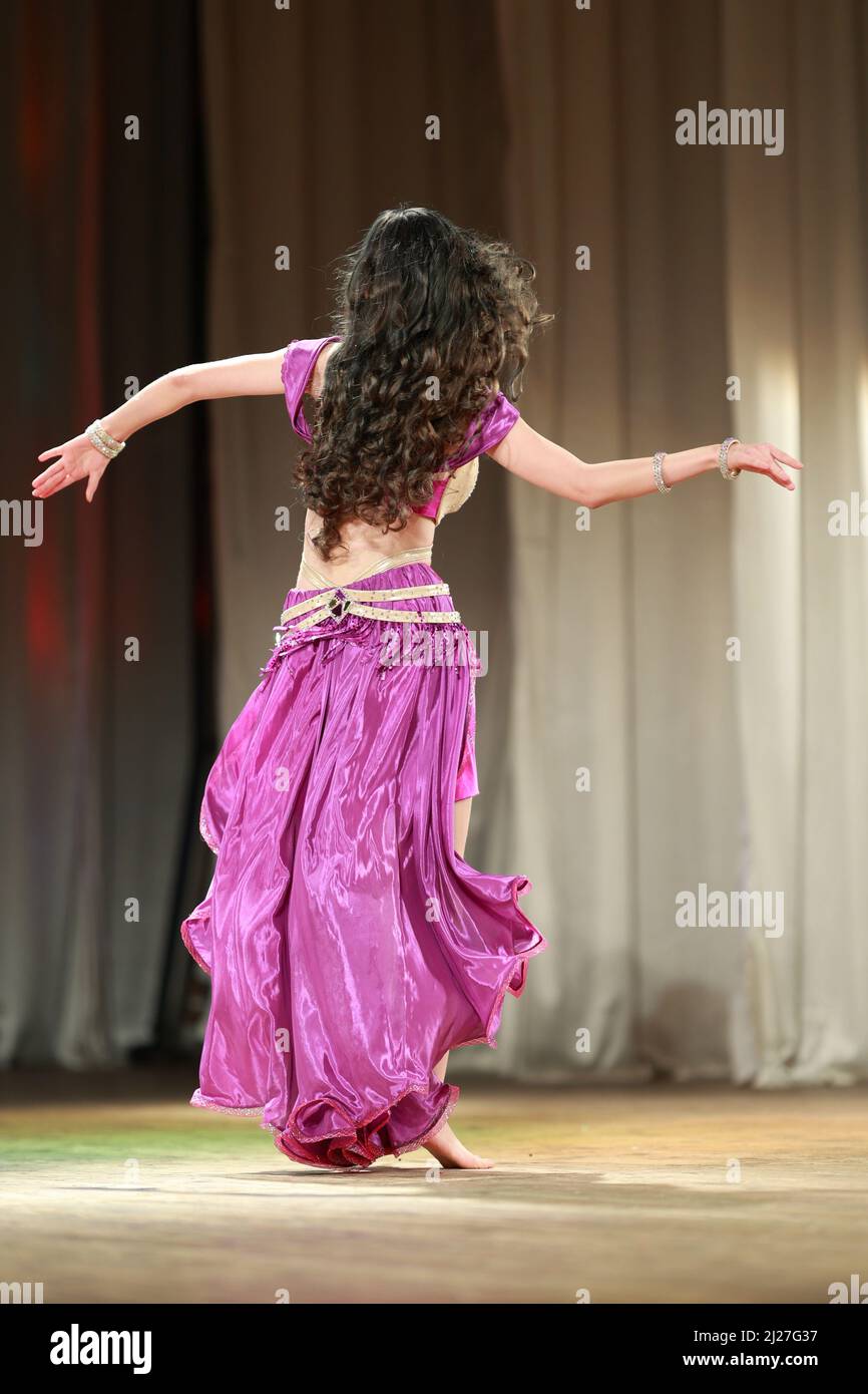 Girls dancers perform on stage with multicolored lights. Backstage