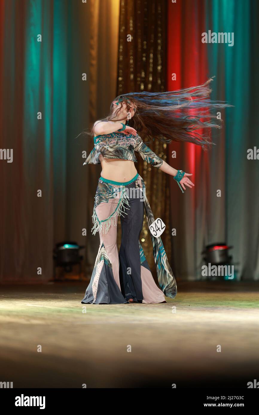 Girls dancers perform on stage with multicolored lights. Backstage