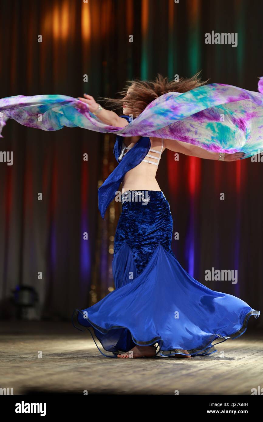 Girls dancers perform on stage with multicolored lights. Backstage