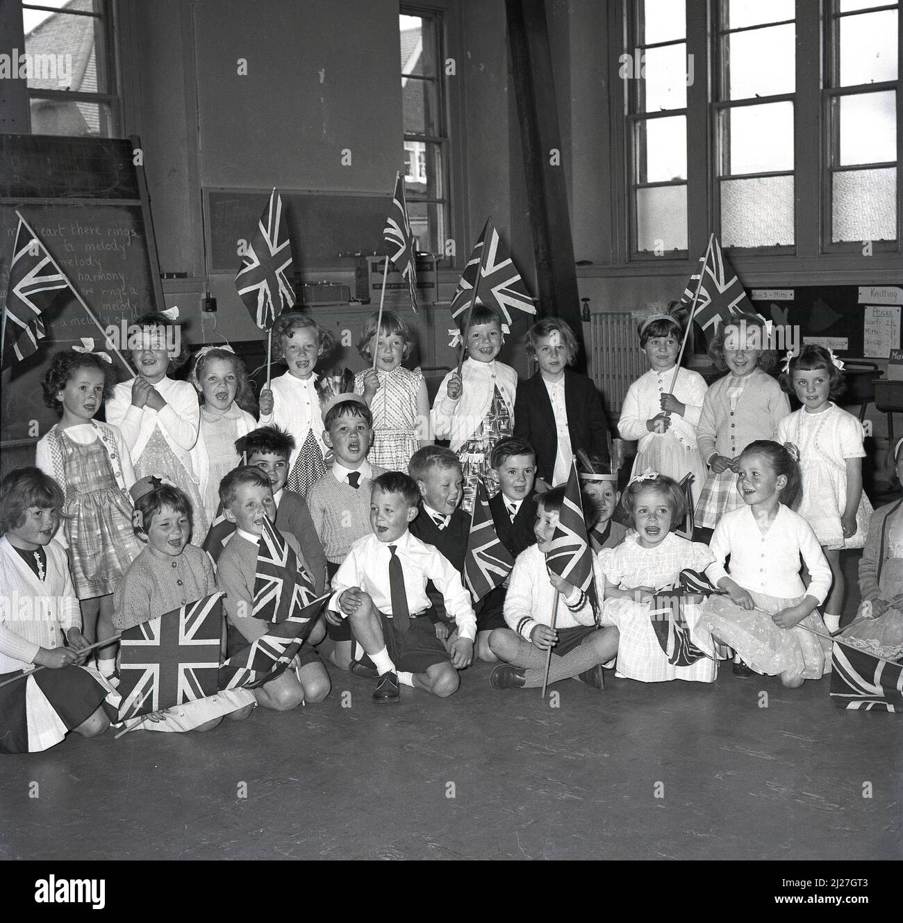 1965, historical, group of excited primary school children sitting in a