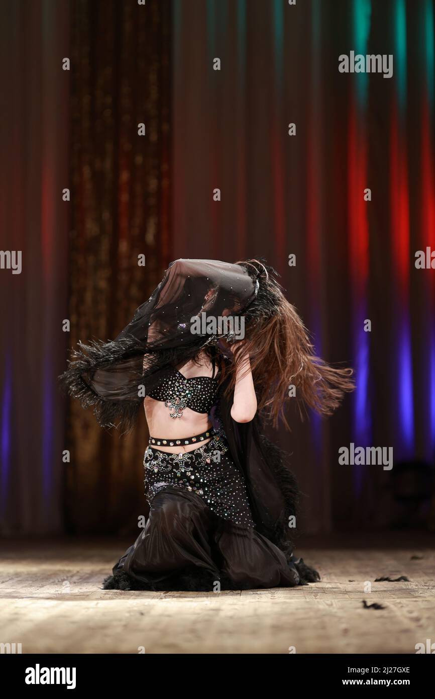 Girls dancers perform on stage with multicolored lights. Backstage