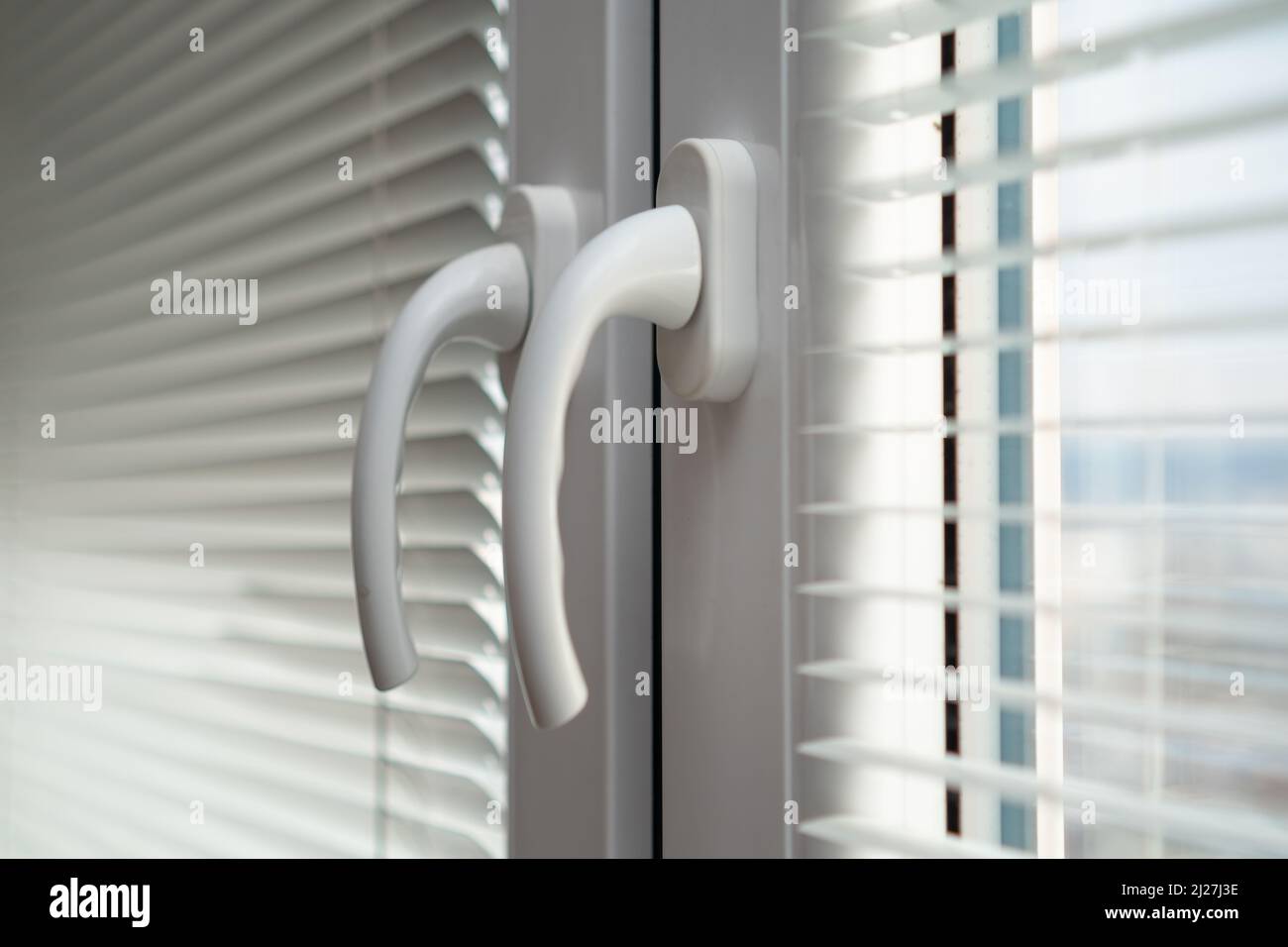 Handles of closed white plastic window with blinds Stock Photo Alamy