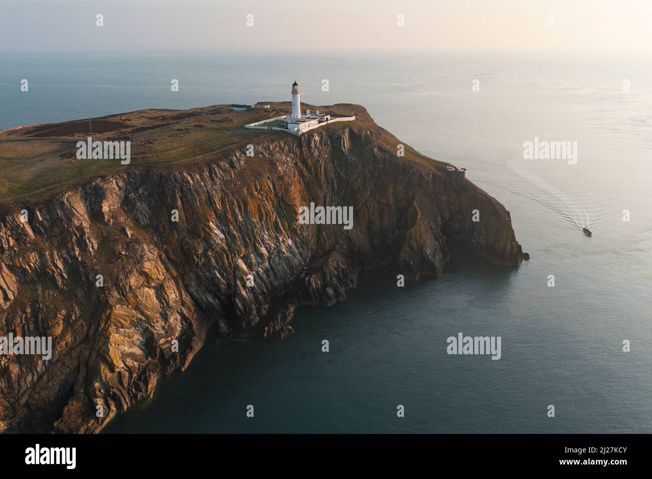 Aerial view at sunrise of Mull of Galloway Lighthouse at southern most point in Scotland, in Dumfries and Galloway, Scotland, UK Stock Photo