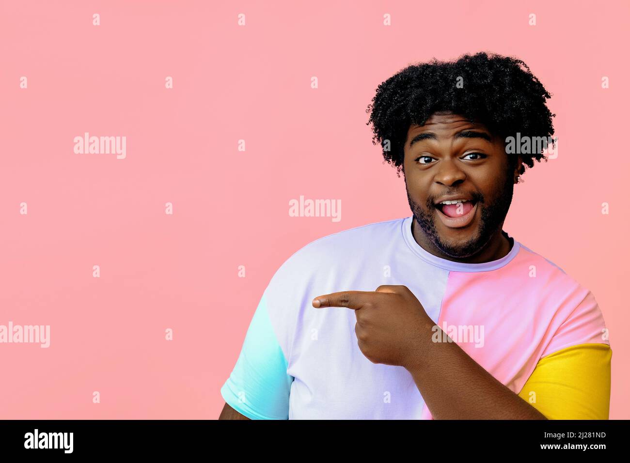 young african american man posing in the studio over pink background male model posing  Stock Photo