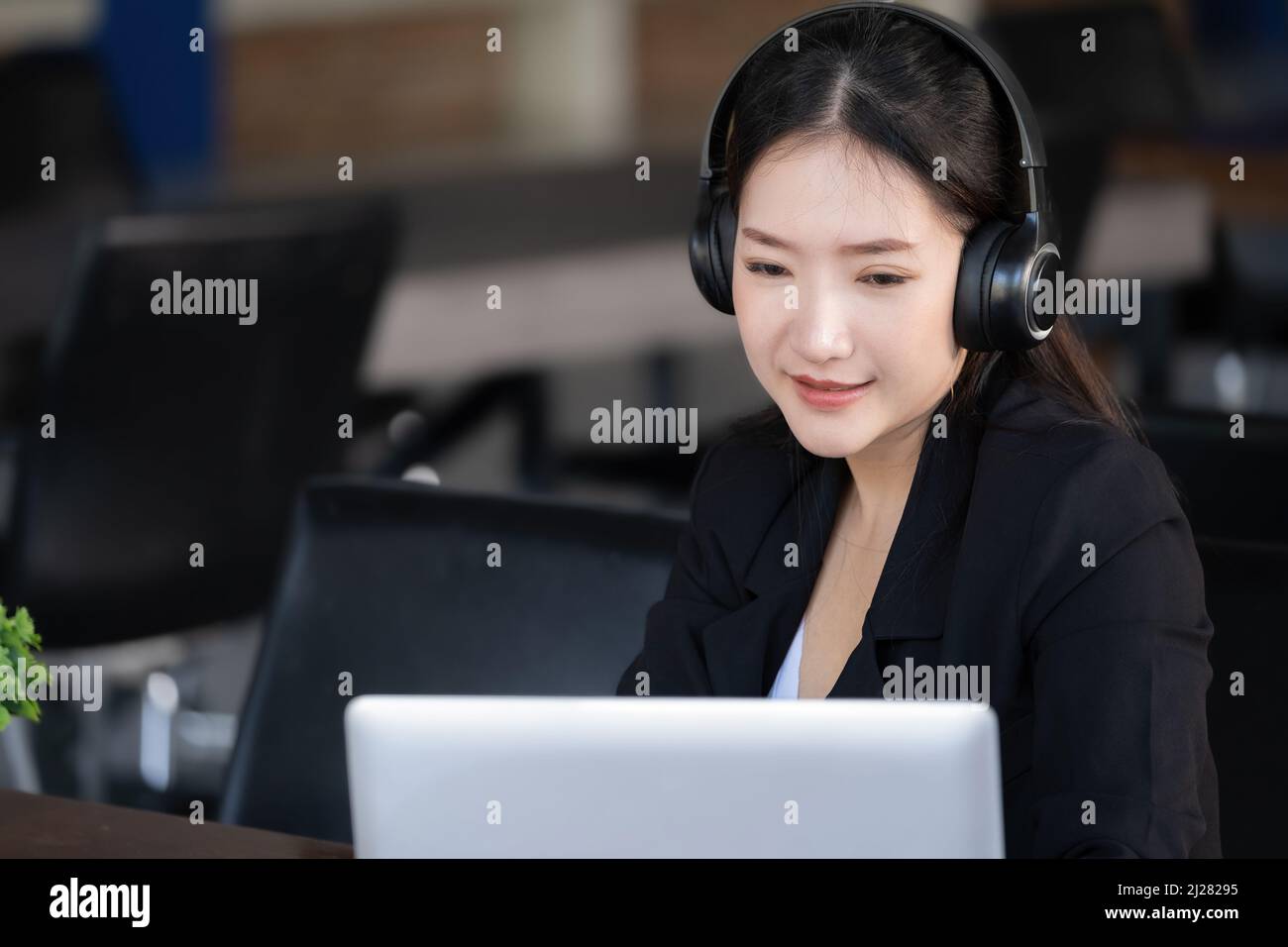 Concept of taking a break from work, an accountant or a female company employee or a business owner is using headphones to listen to music to relieve Stock Photo