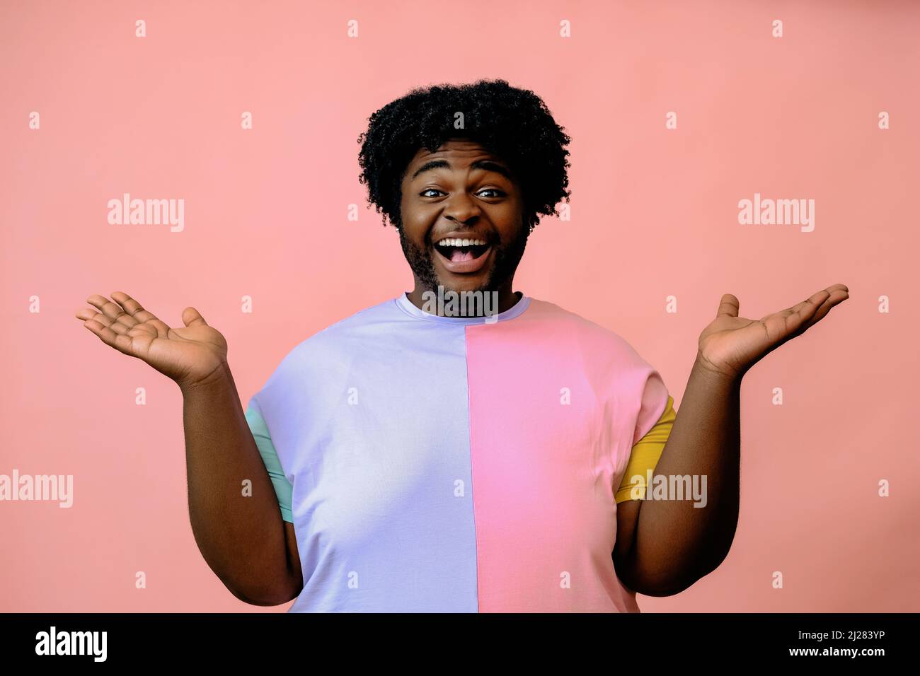 young happy african american man posing in the studio over pink background black male model posing  Stock Photo