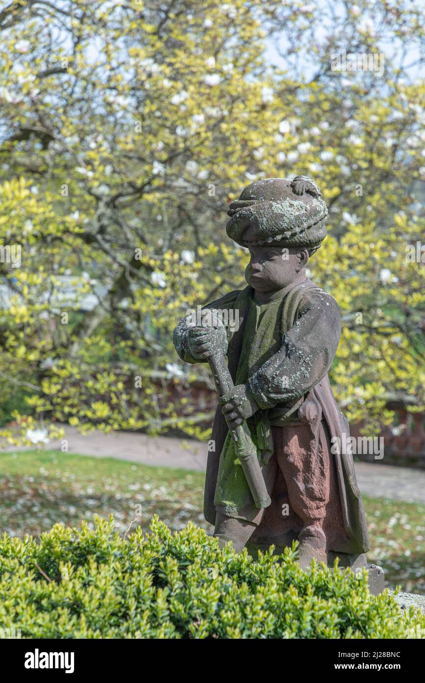 Frankfurt, Germany - April 24, 2021: old sandstone figures showing young arabic musicians in style of the 18th century in the park of the Bolongaro bu Stock Photo