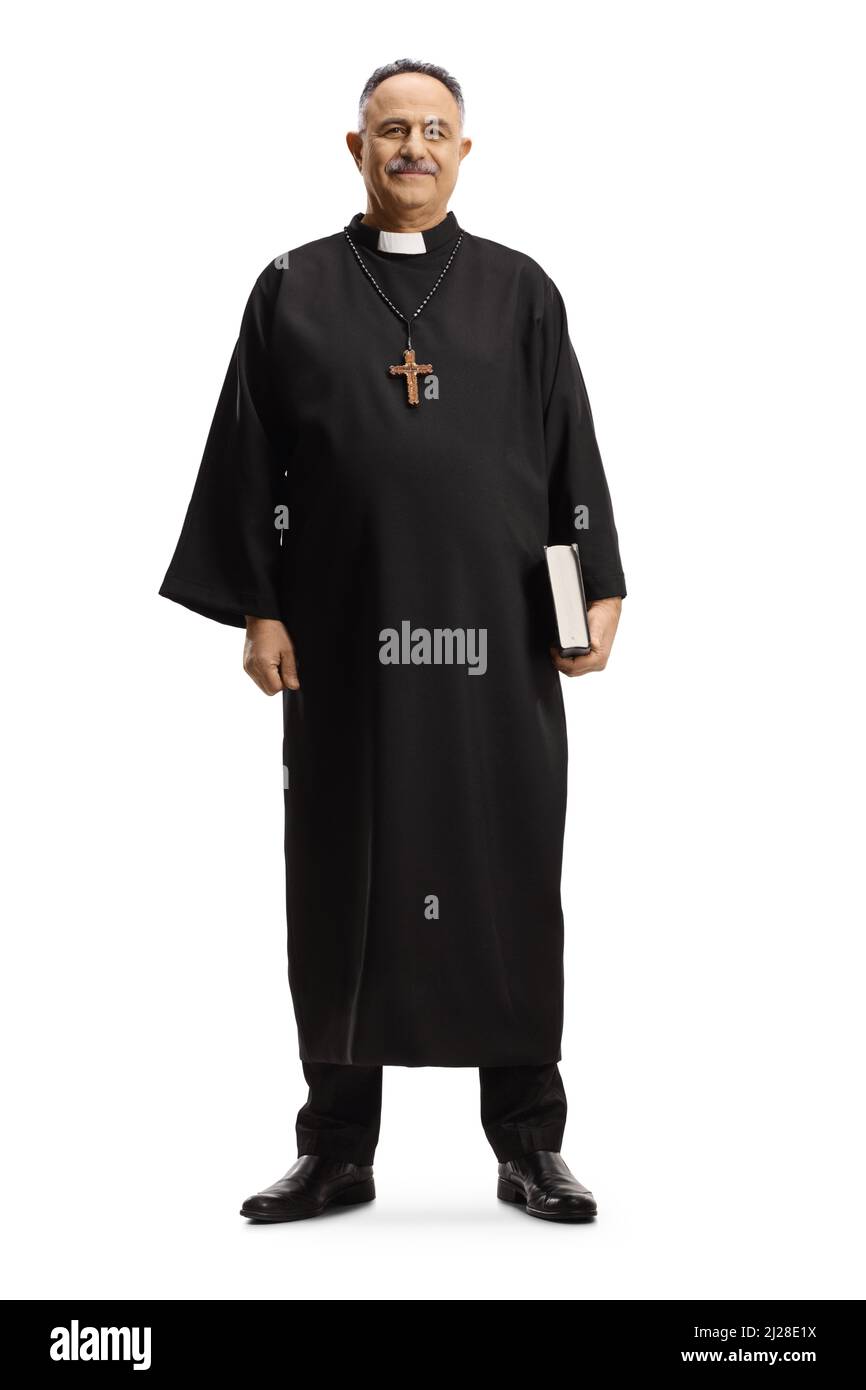 Full length portrait of a priest walking holding a bible and smiling at camera isolated on white background Stock Photo