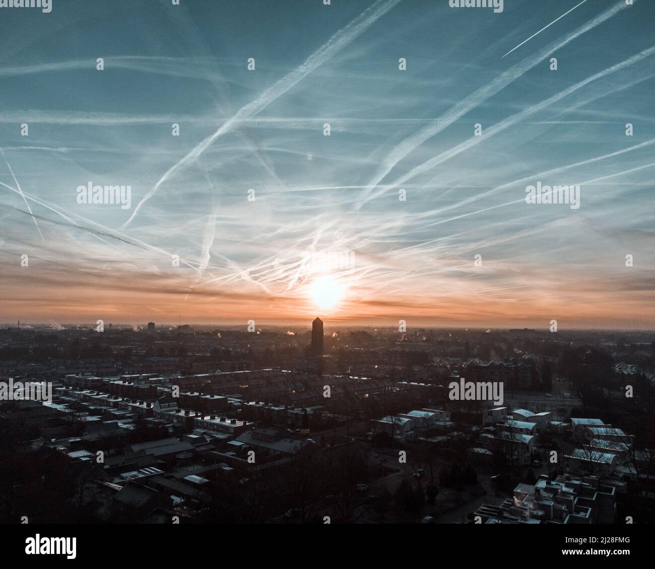 A scenic view of lots of contrails in the sky over the city Stock Photo