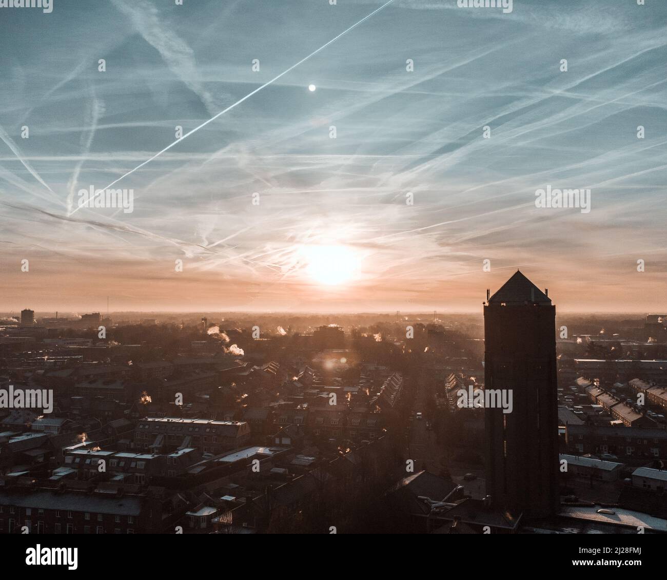 A scenic view of lots of contrails in the sky over the city Stock Photo