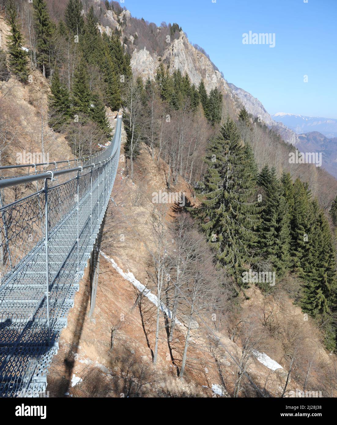 long Tibetan bridge connecting the mountain ridges in winter without people Stock Photo